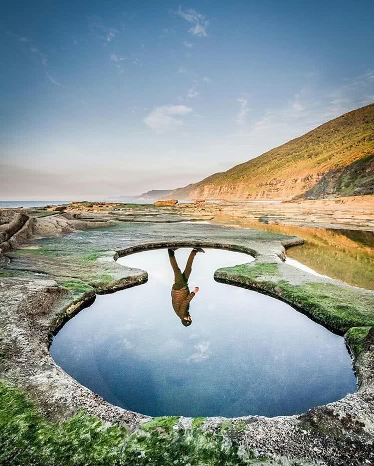 A body of water with a mountain in the background