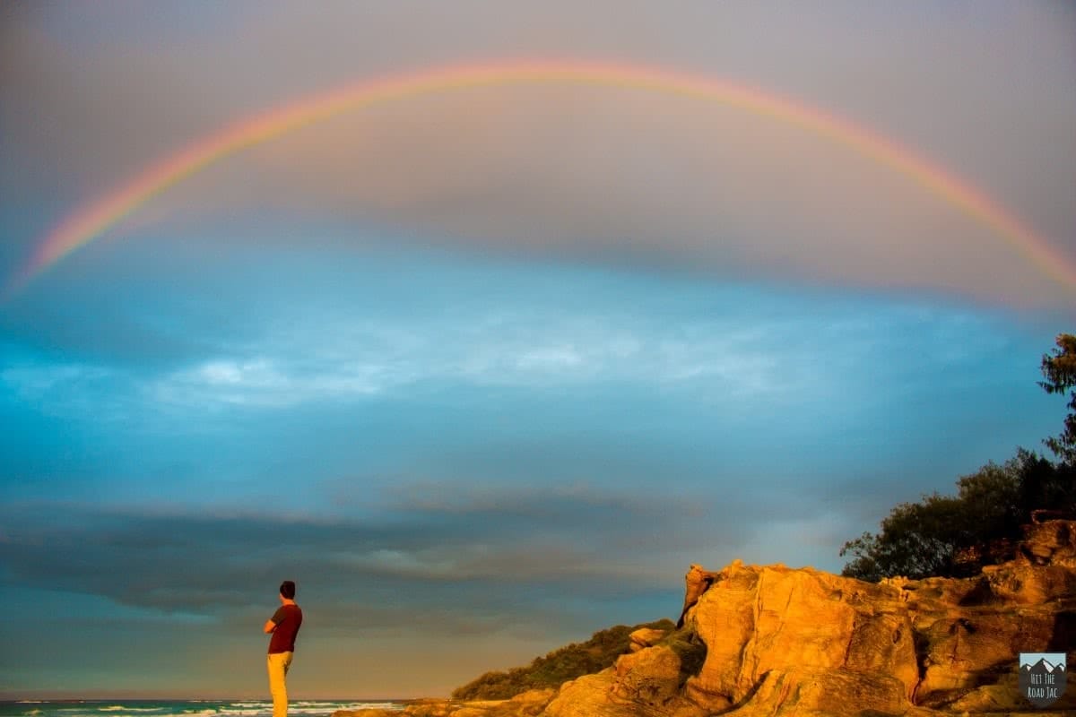 Across the Ditch To Minjerribah // Stradbroke Island (QLD), Jacquie Tapsall, rainbow, person, headland, ocean,