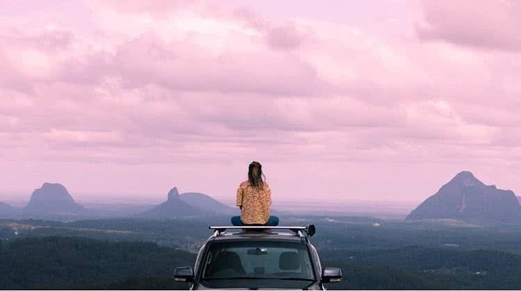 Top 10 Road Trips in Queensland, Darcy Swain, Sunshine Coast, Glasshouse mountains, pink sky, woman, car
