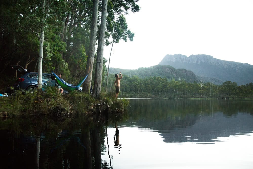 12 Things To Do On Tassie’s West Coast, photo by Nick Green, Lake rosebury, man, hammock, mountains, forest