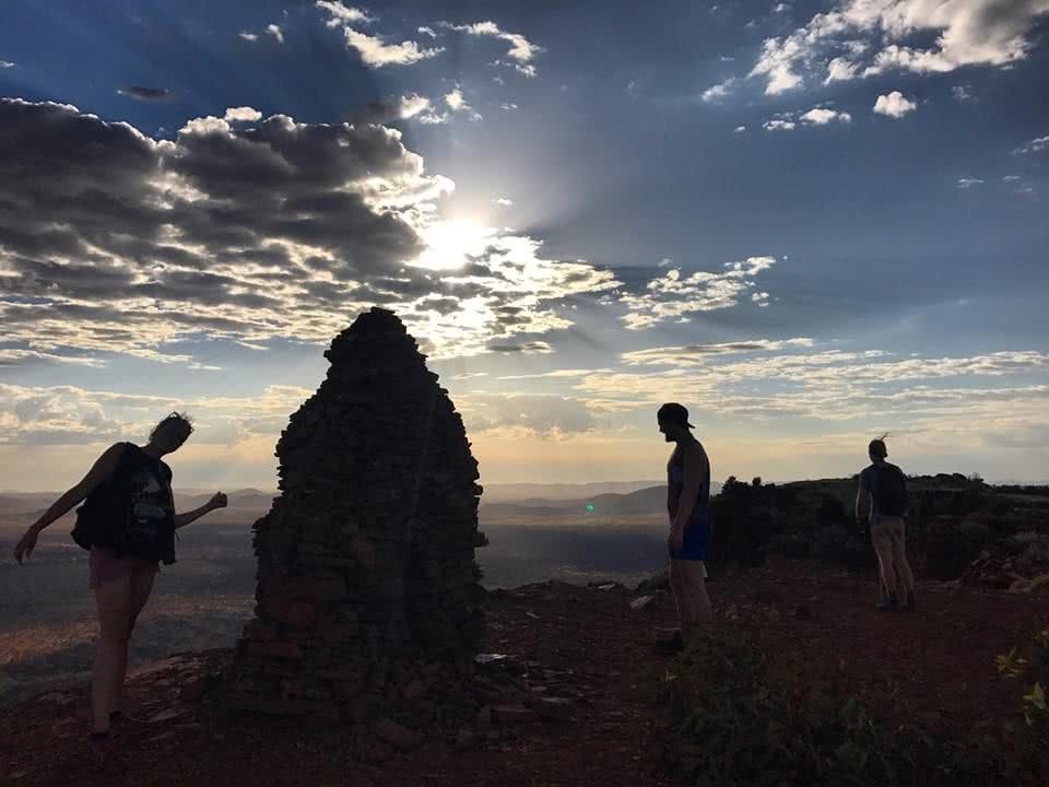 Starting The Day The Right Way On Punurrunha (Mt Bruce) // Karijini NP (WA) Tiffany Hulm, mountain, people, cairn, rock pile, sky, sunrise, backlit clouds, silhouettes