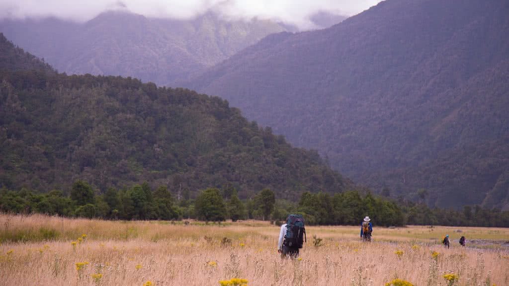 Ode To The River // Canyoning And Packrafting In New Zealand, Xavier Anderson, field, grass, hills, mountains, hikers, backpacks