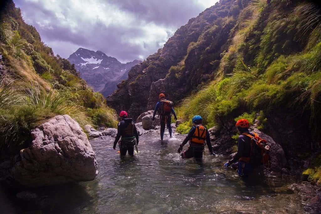 Ode To The River // Canyoning And Packrafting In New Zealand, Xavier Anderson, wading, crew, group, helmets, view, mountains