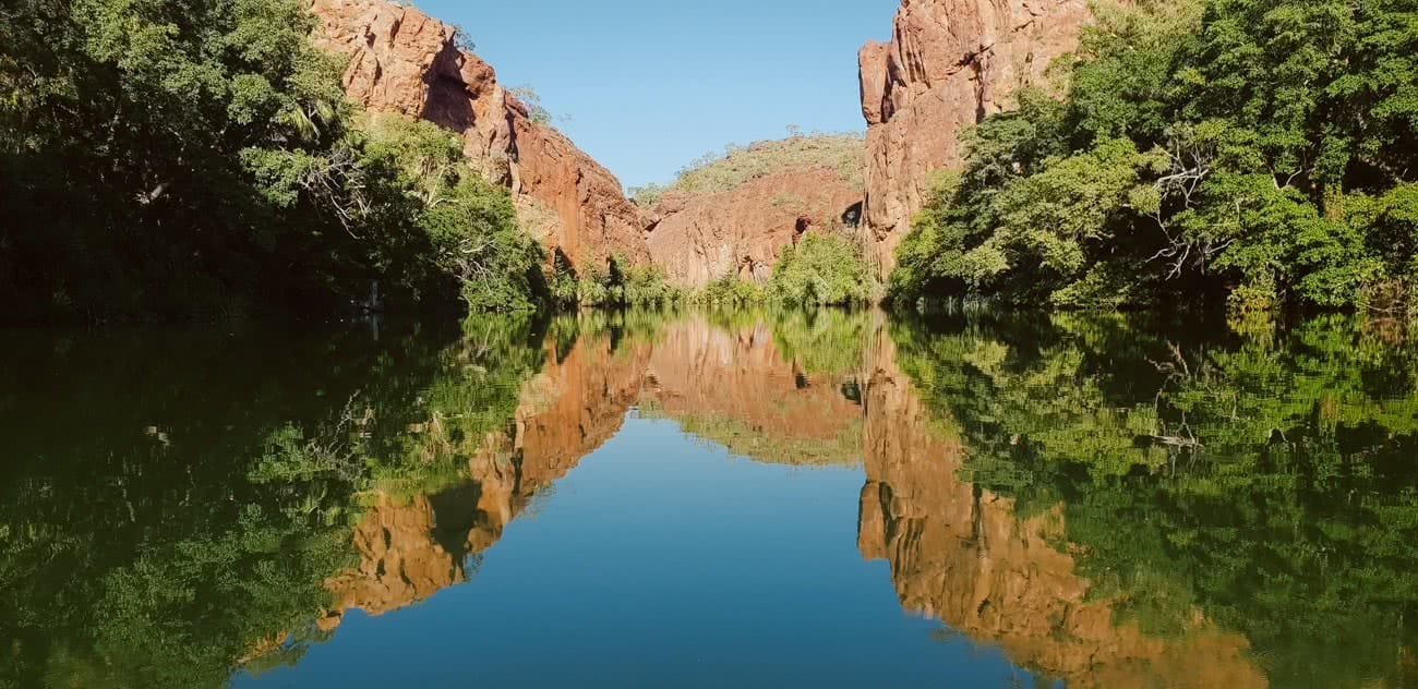 Out There In An Outback Oasis // Adels Grove (QLD), Grace and Brenton Keller, glassy, mirror, reflection, cliffs, red rock, bush, swimming hole, lawn hill creek