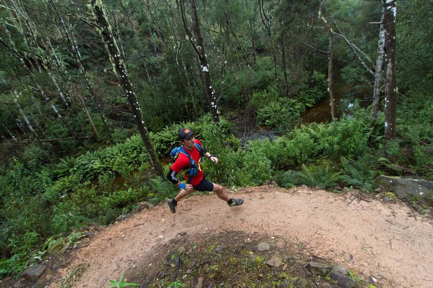 The Ultimate Beginner’s Guide To Trail Running, Chris Ord, single track, runner, hydration pack, woods, trees