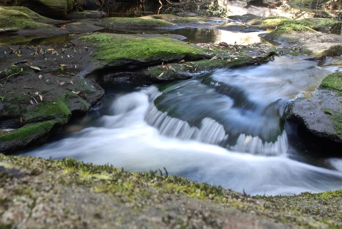 An Explorer's Guide To Hiking With A Camera by Zac de Silva river, rocks, waterfall, photography