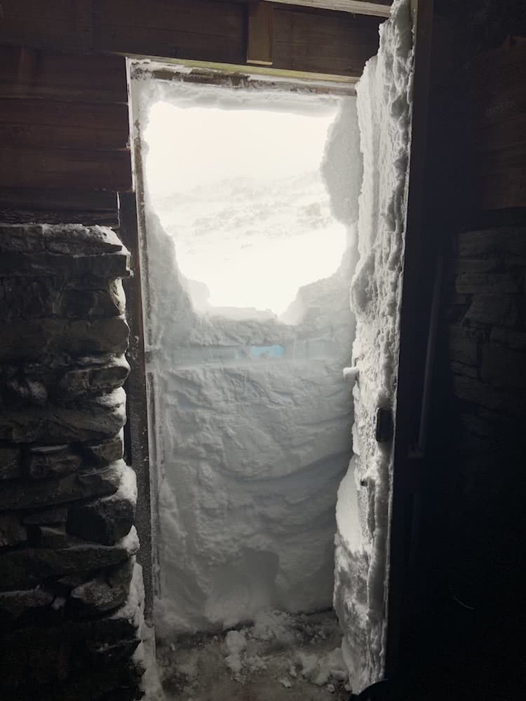 You Can Walk The Overland Track For Free (But There’s A Good Reason), photo by Dom Douglas, overland track, cradle mountain lake st clair, multi day hike, snow, tasmania, doorway, snowed in