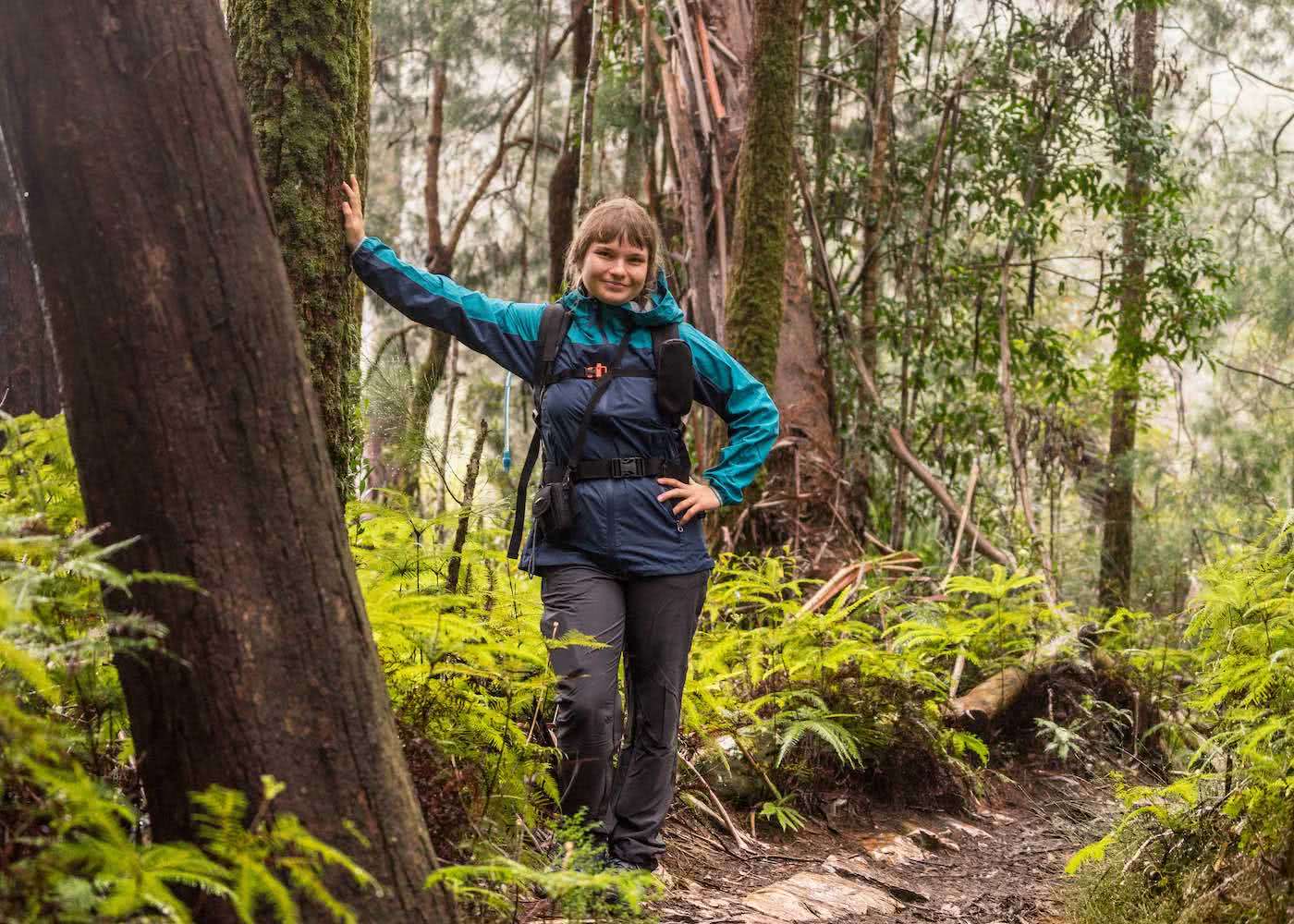 Miranda Fittock, I Tested A Full Kit Of Cheap ALDI Hiking Gear Over Nearly 100km, woman, jacket, trees, leaning