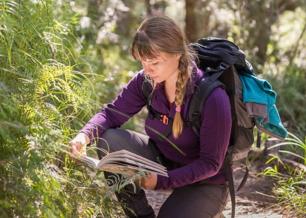 I Tested A Full Kit Of Cheap ALDI Hiking Gear Over Nearly 100km, woman, fleece jumper, hiking pack, kneel, wildflowers