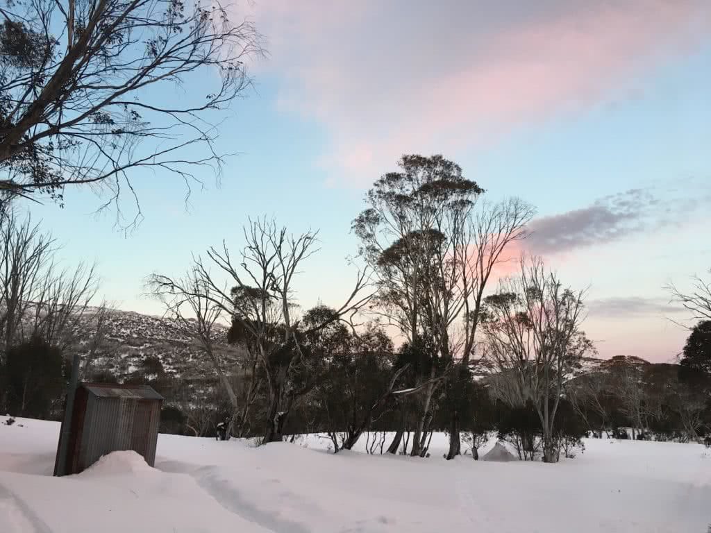 Snowshoeing Across The Aussie Alps, pink sky, sunset, snow, hut, gumtrees