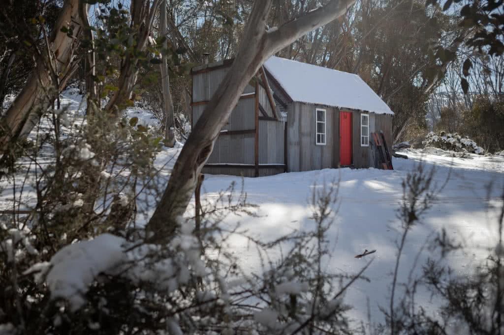 Snowshoeing Across The Aussie Alps, hut, red door, snow, gumtrees