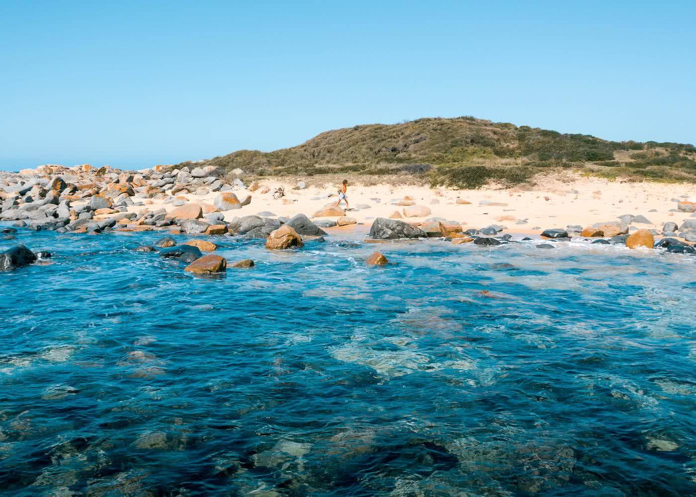 Step Back In Time Along The Bingi Bingi Dreaming Track // Eurobodalla (NSW), photo by Fin Matson, drone shot, ocean, rocks, beach, Bingi Bingi Point, woman, hiking