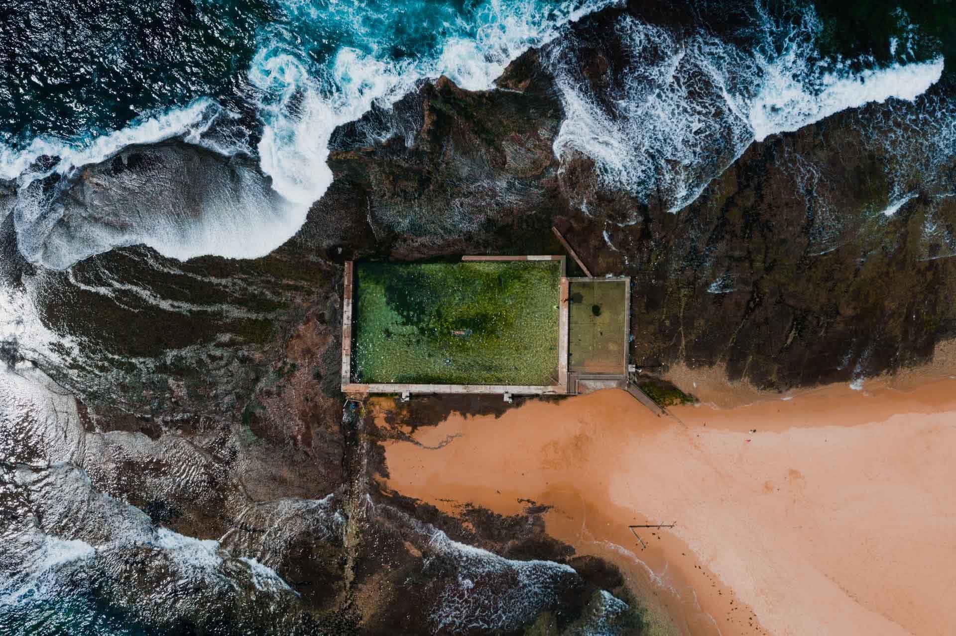 Here's All The Ocean Pools In Sydney's Northern Beaches, Jonathan Tan, Mona Vale Rock Pool, overhead shot, pool, ocean, rocks, waves, beach, sand