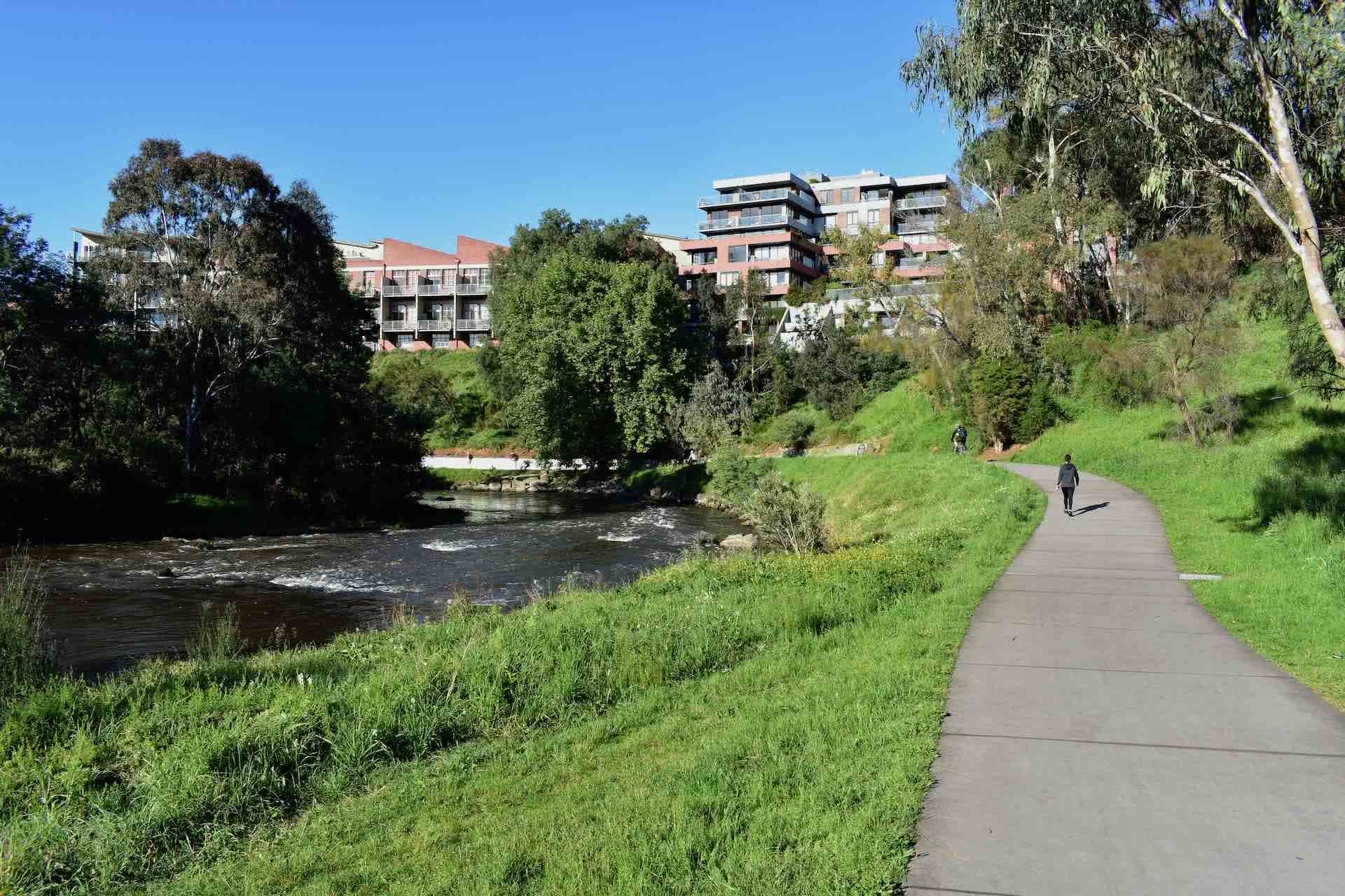 Summer's Arrived! Here's How You Can Make The Most Of It In Melbourne, Em Barlow, Yarra Trail near Dight Falls, path, trees, creek, buildings