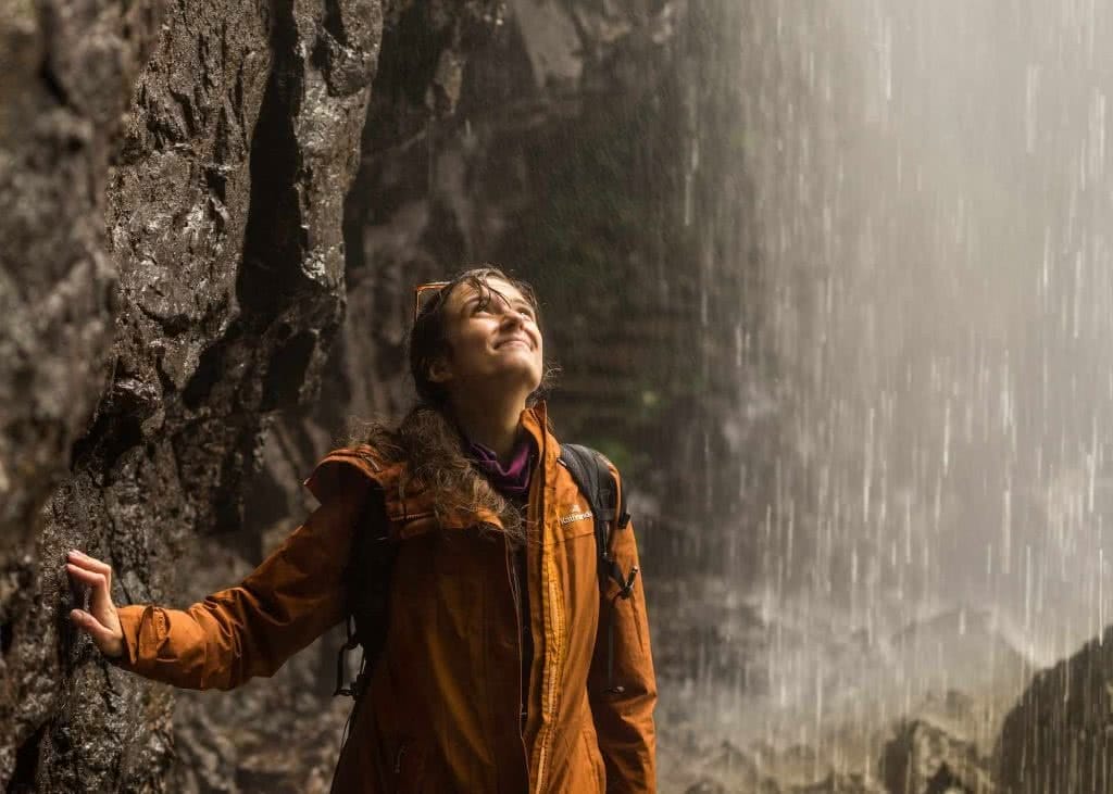 photo by Miranda Fittock, woman, waterfall, hike, rain, jacket