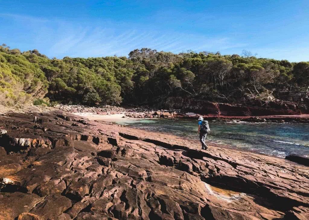 Secluded Camping on the Light to Light Walk, Alice Wisse, Ben Boyd National Park, Hegartys Bay, ocean, cliffs, red rock, man, hike