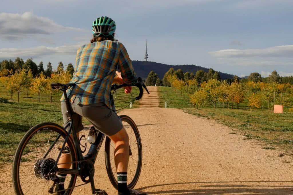 A man riding a bike down a dirt road