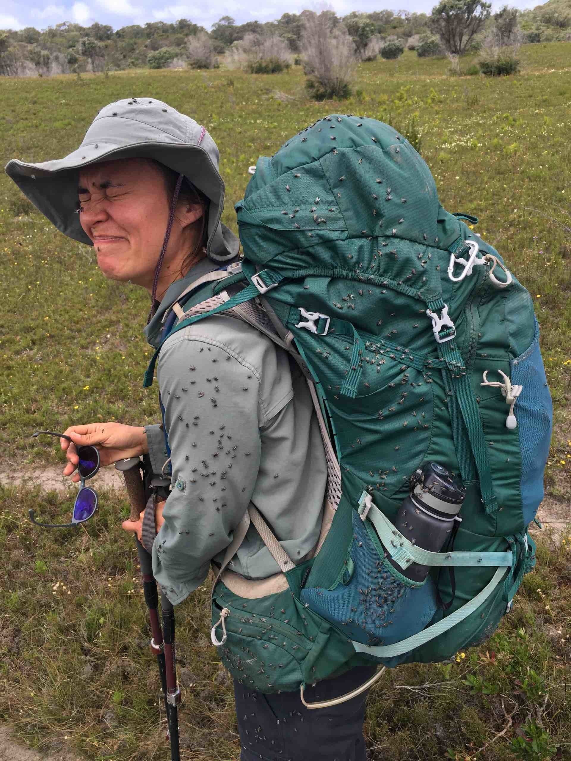 Hiking the Bibbulmun Track: A Thousand Emotions in 1000km, Photos by Steve Willems and Caroline Grandjean-Thomsen, woman, hike, pack, flies, grimmace, hat