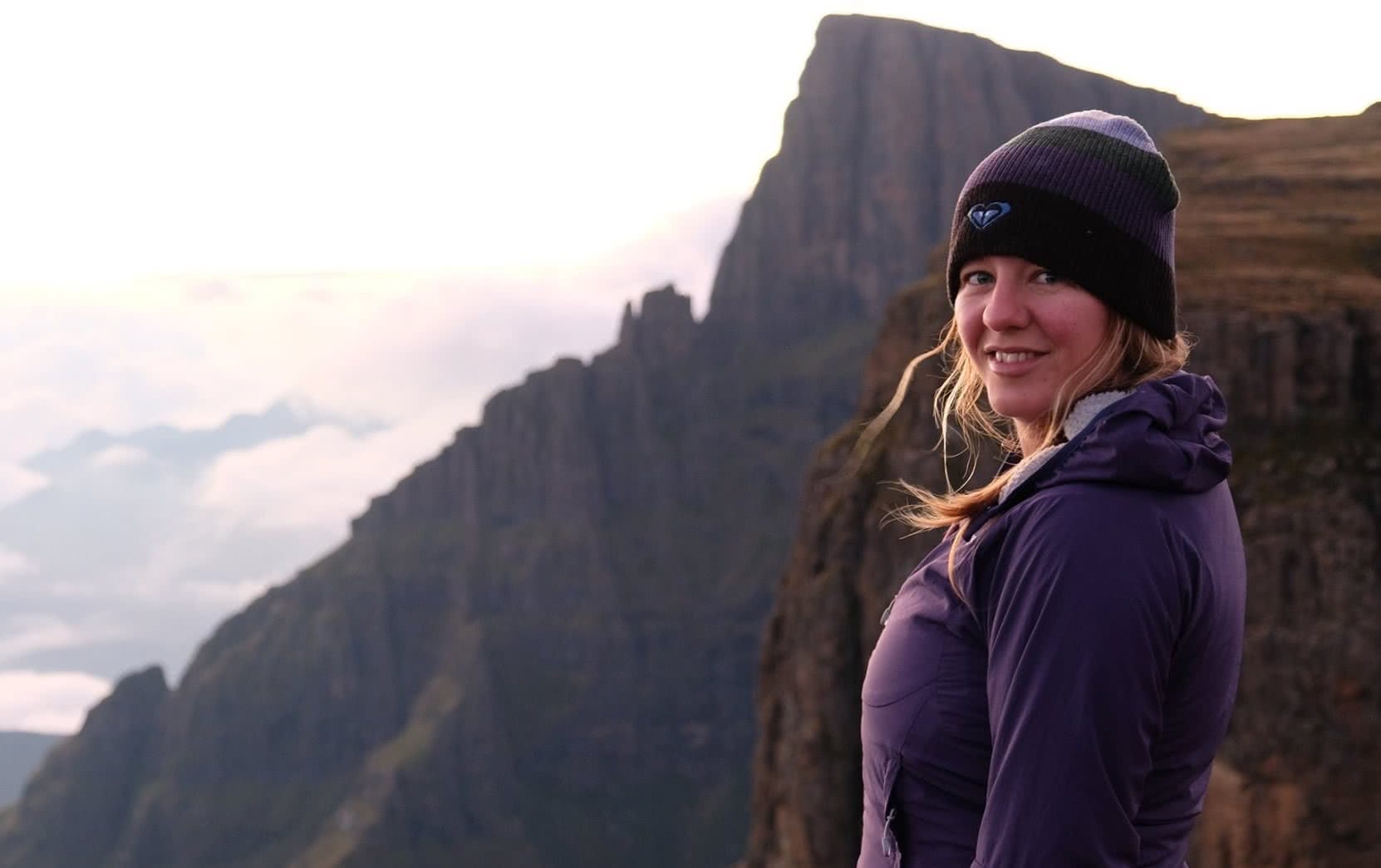 A person standing in front of a mountain