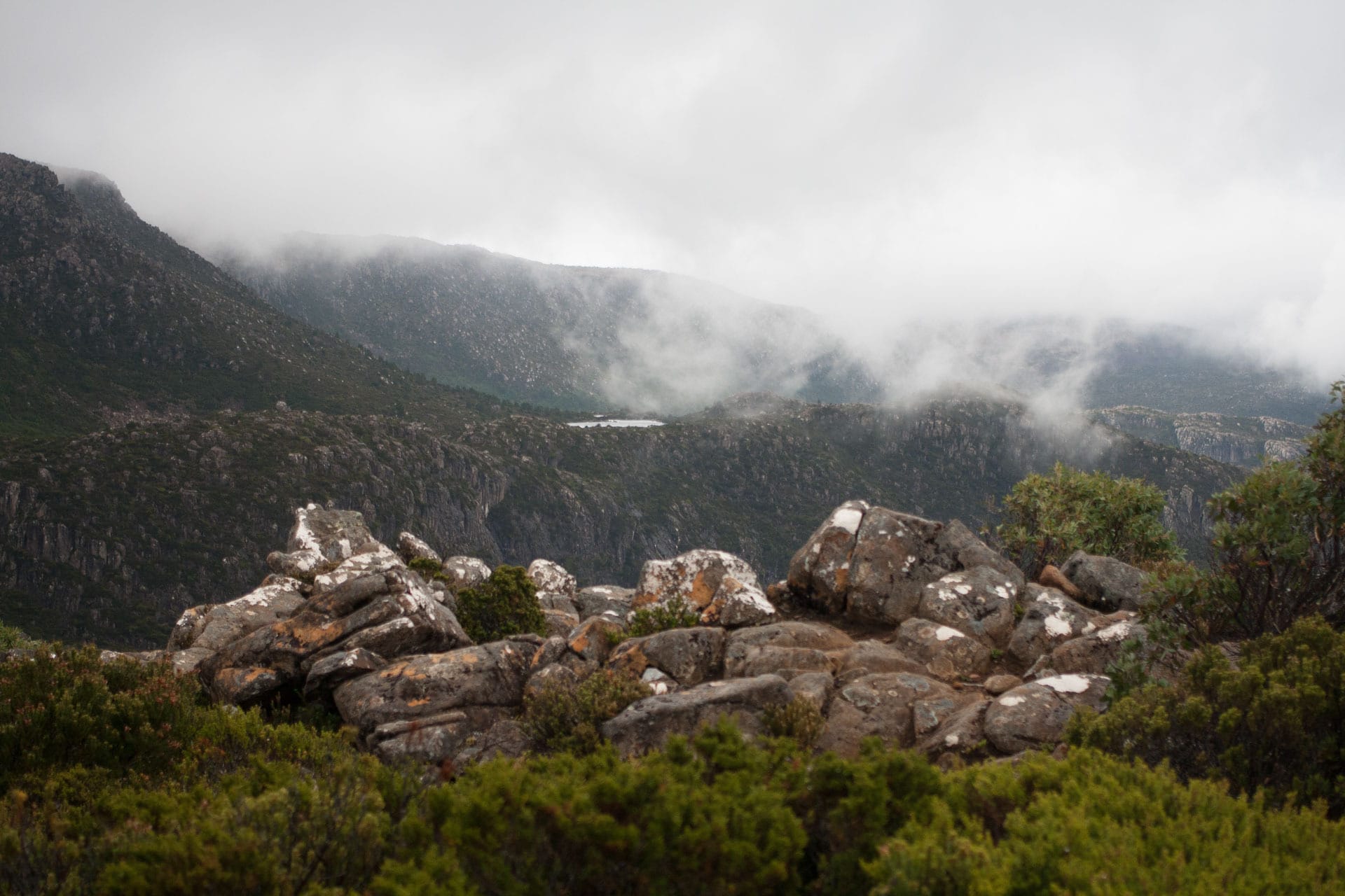 The clouds clear to reveal the first Tarn in the distance, The Tarn Shelf – Tasmania's Best Day Hike You've Never Heard Of, casey fung, tarn shelf, mt field national park, tasmania