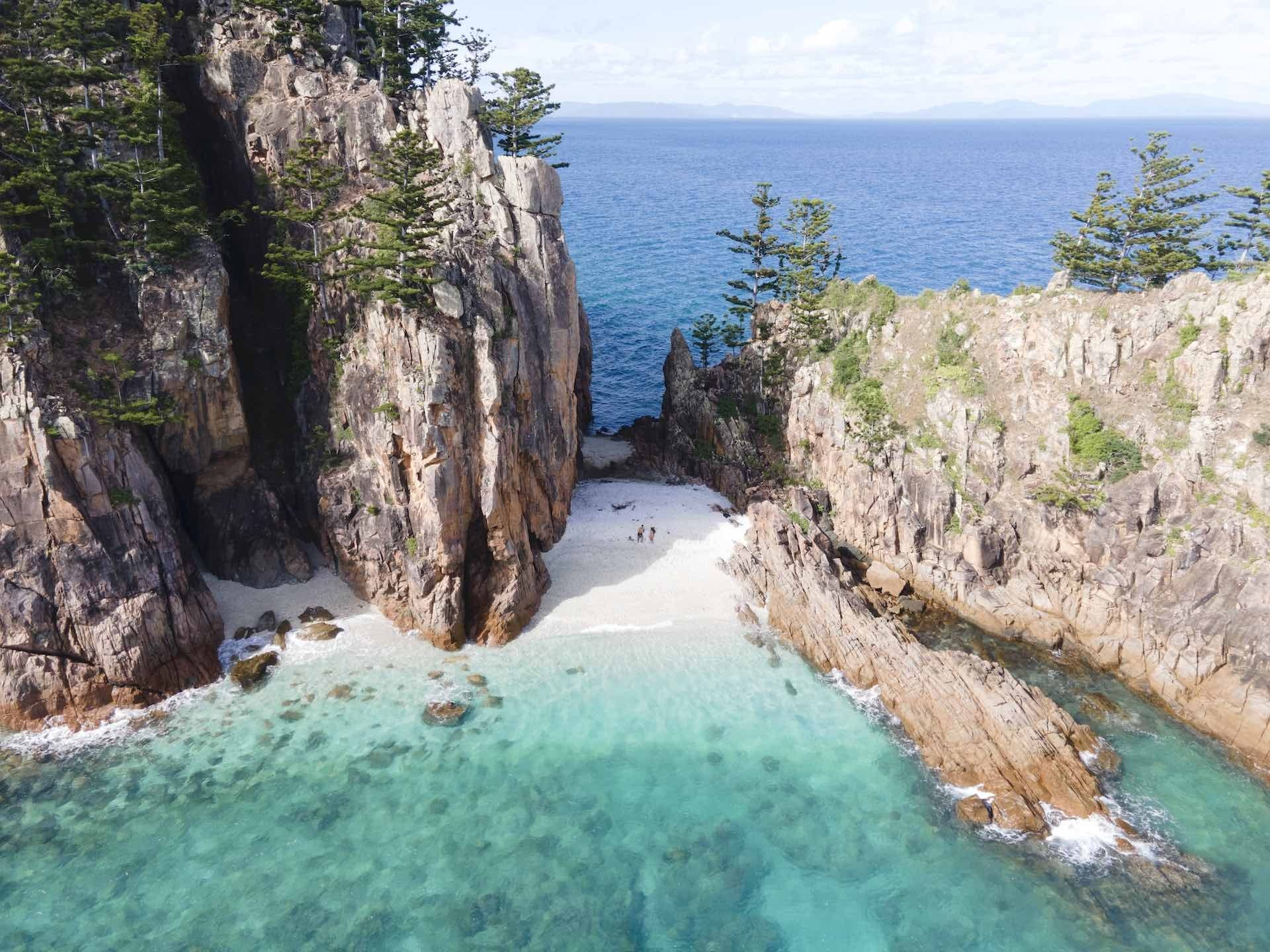 Australia's Top 10 Beaches of 2022 Have Been Revealed, Tourism & Events QLD, Blue Pearly Bay, Hayman Island, drone shot, cliffs, ocean