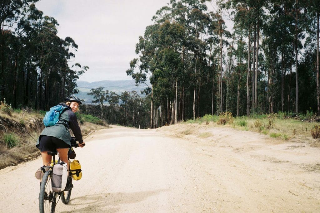 A man riding a bike down a dirt road