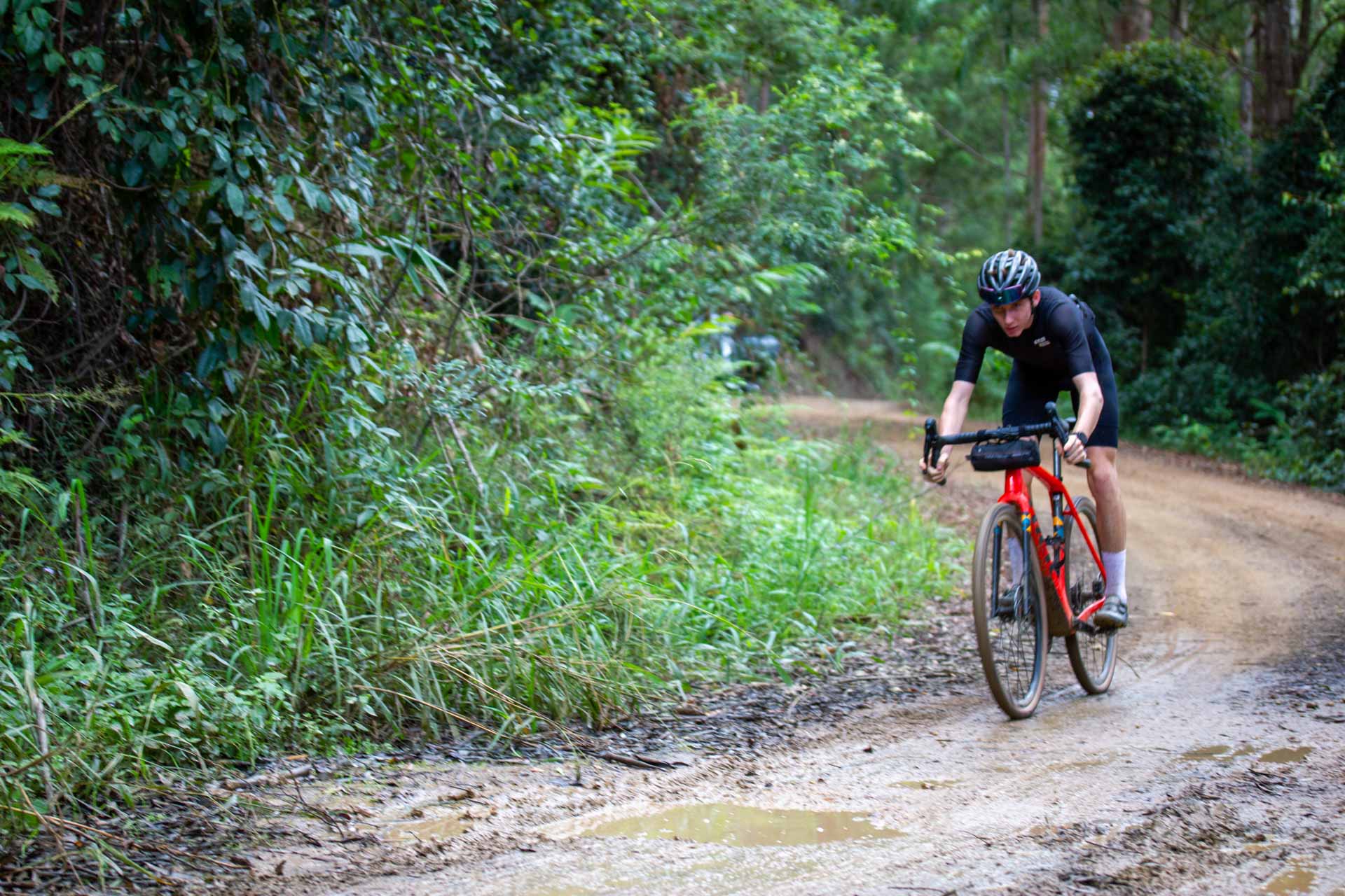 What the Heck Is a Gravel Bike?, Max Hobson, trek, person riding gravel bike, dirt road, muddy puddle