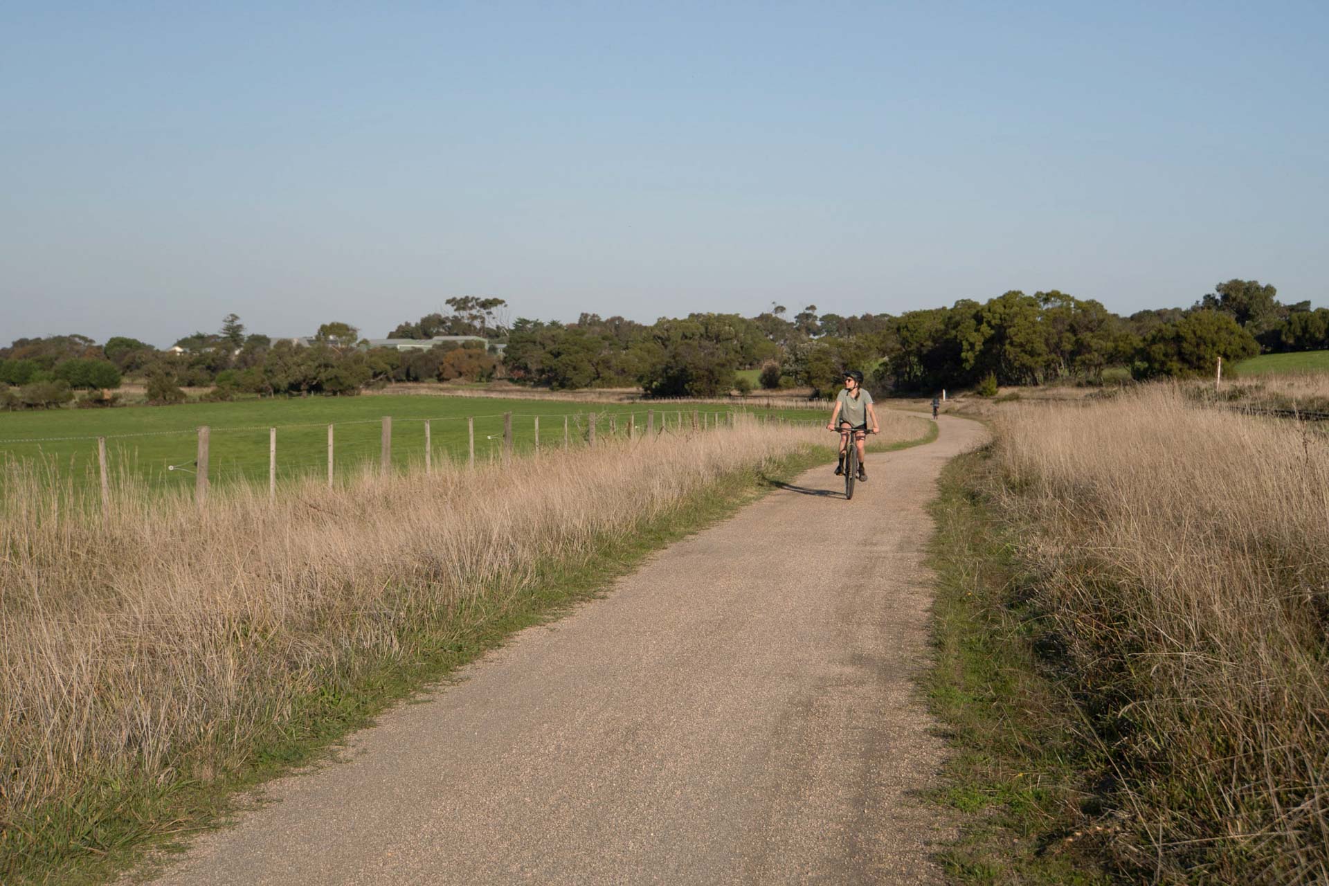Bellarine Rail Trail – Explore Victoria’s Farmland and Coast on This 35km Cycling Track, Alyson Lamb, person riding a bike through farmland in victoria