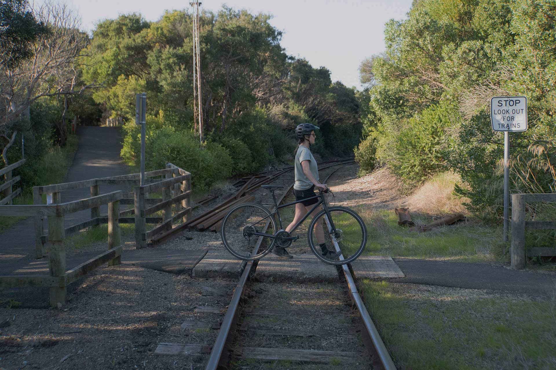Bellarine Rail Trail – Explore Victoria’s Farmland and Coast on This 35km Cycling Track, Alyson Lamb, person walking a bike across rail tracks