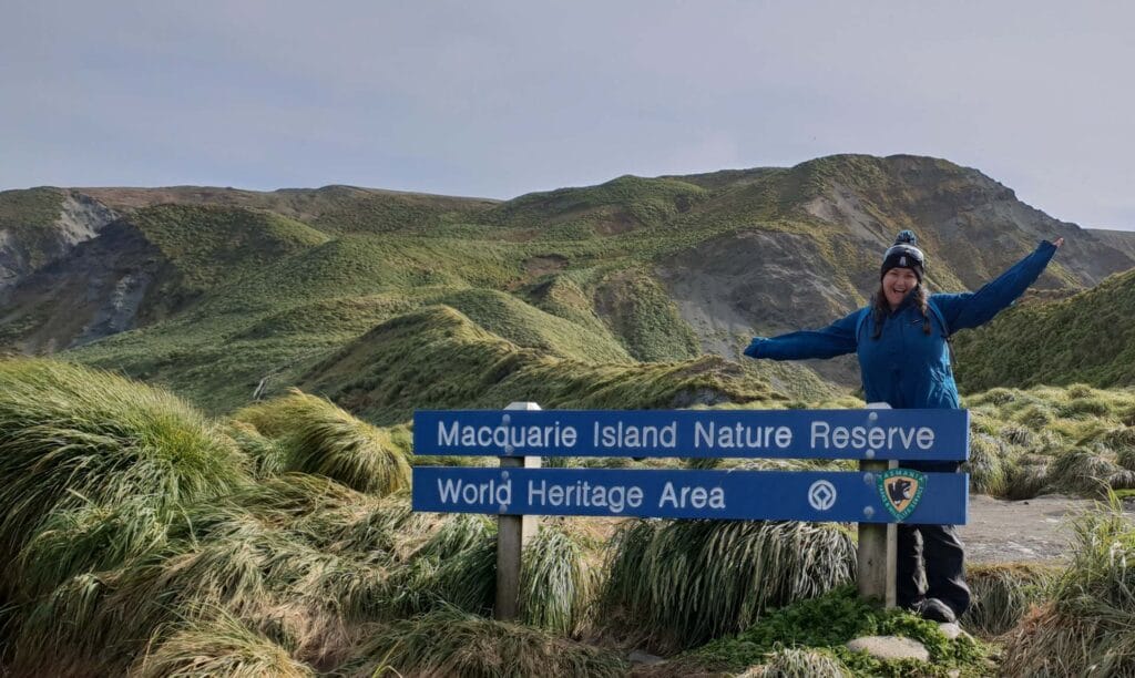 Rediscovering My Wild On The Edge Of The Southern Ocean, Hannah Watts, person standing in front of a sign on macquarie island