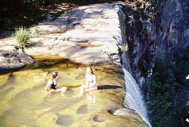 Belmore Falls: A Secluded Waterfall Looking Over the Picturesque Kangaroo Valley, Kyra Mckinnon, people sitting on the edge of a waterfall, kangaroo valley