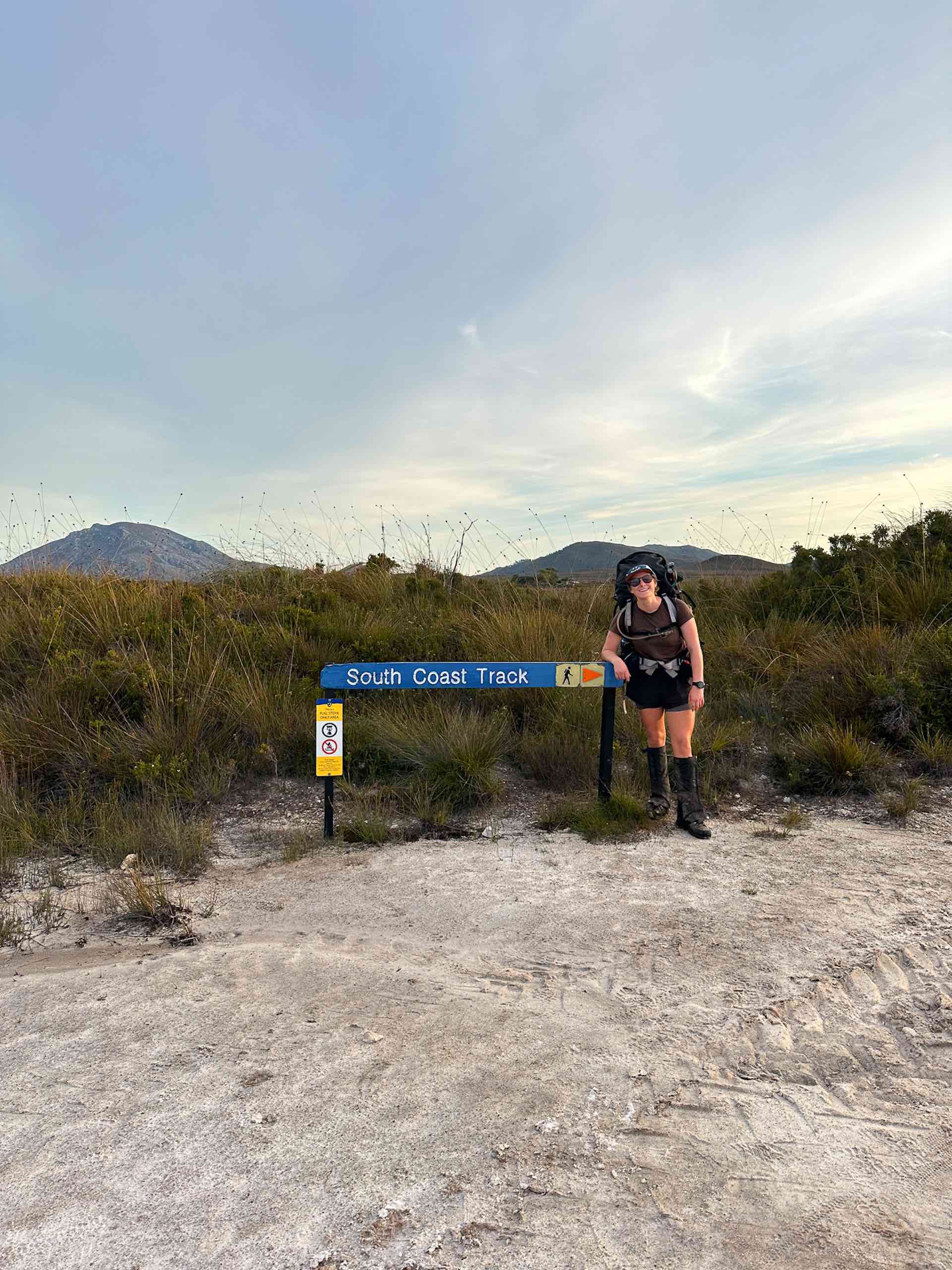 South Coast Track – 5 Days Hiking in Tassie’s Remote Southwest National Park, Alissa Ward, Tasmania, hiker with sign, happy hiker