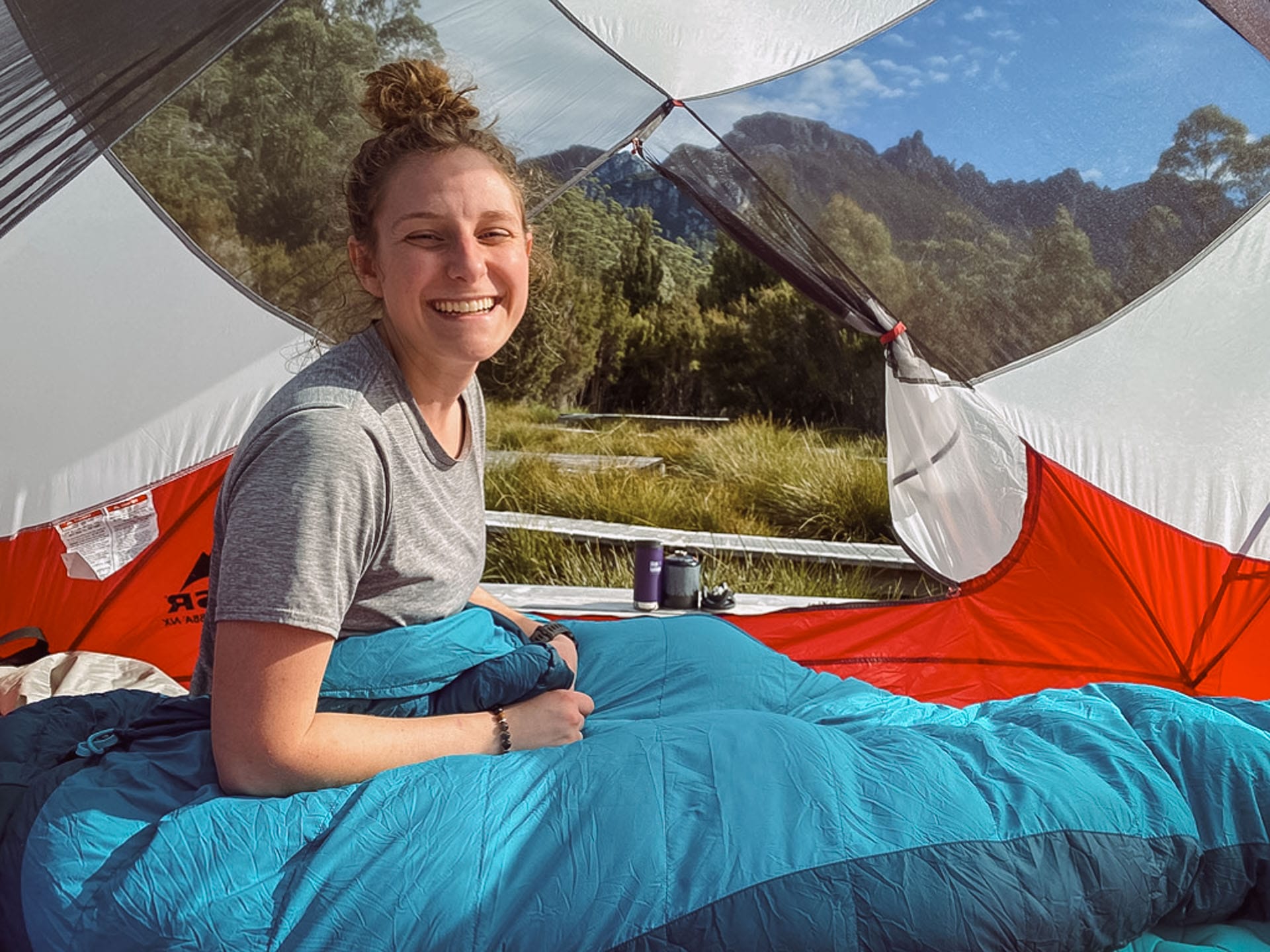 Why I Calculated the Opportunity Cost of Hiking, tent, camping, woman smiling while inside red and white tent