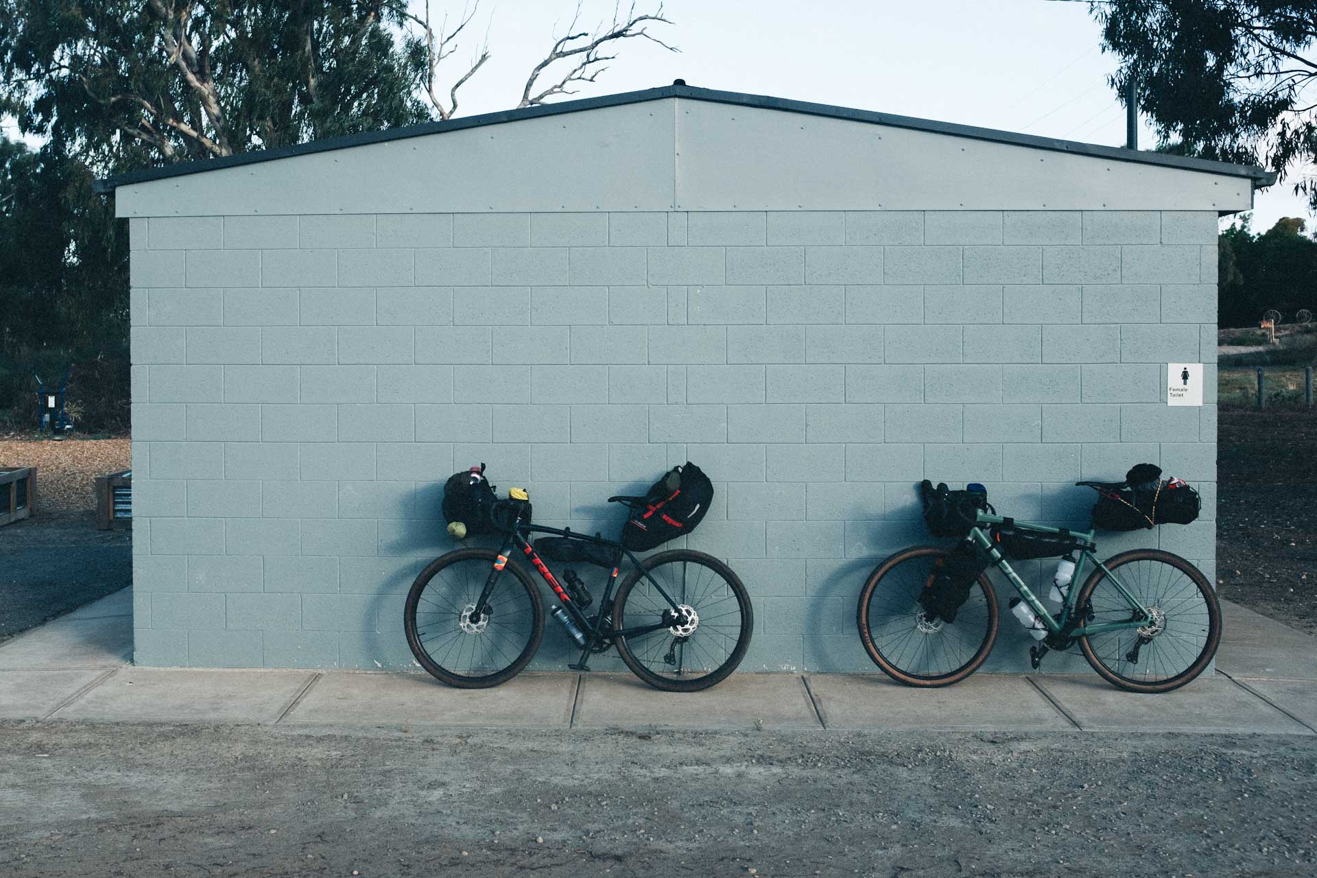 I Went Back To Basics On My Murray River Bikepacking Trip – Here’s What I Learnt, bikepacking, cycling, camping, two black bicycles leaning against a duck egg blue brick wall