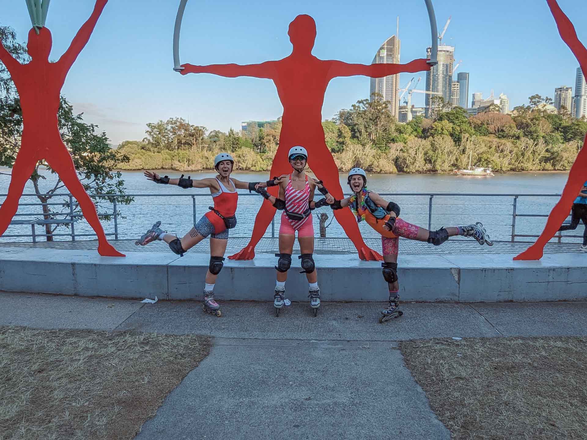 A 4am Rollerblading Commute to Work, rollerblading, brisbane, microadventure, three friends posing for a photo infront of red sculptures on the world expo '88 public art trail