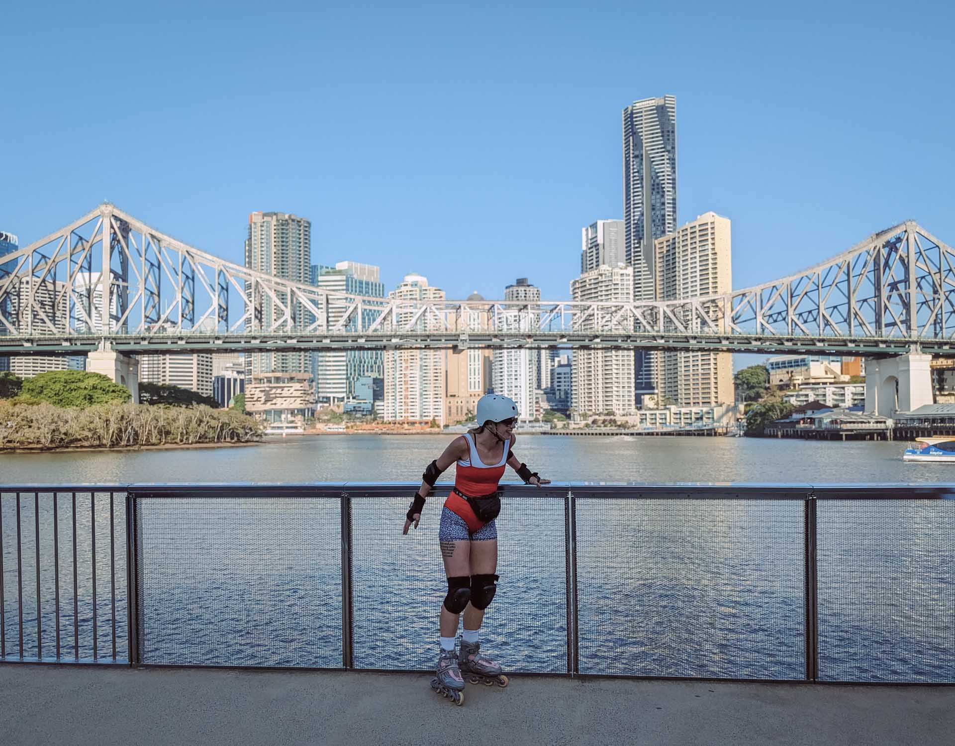 A 4am Rollerblading Commute to Work, rollerblading, brisbane, microadventure, woman in red leotard and rollerblades posing for a photo in front of the story bridge