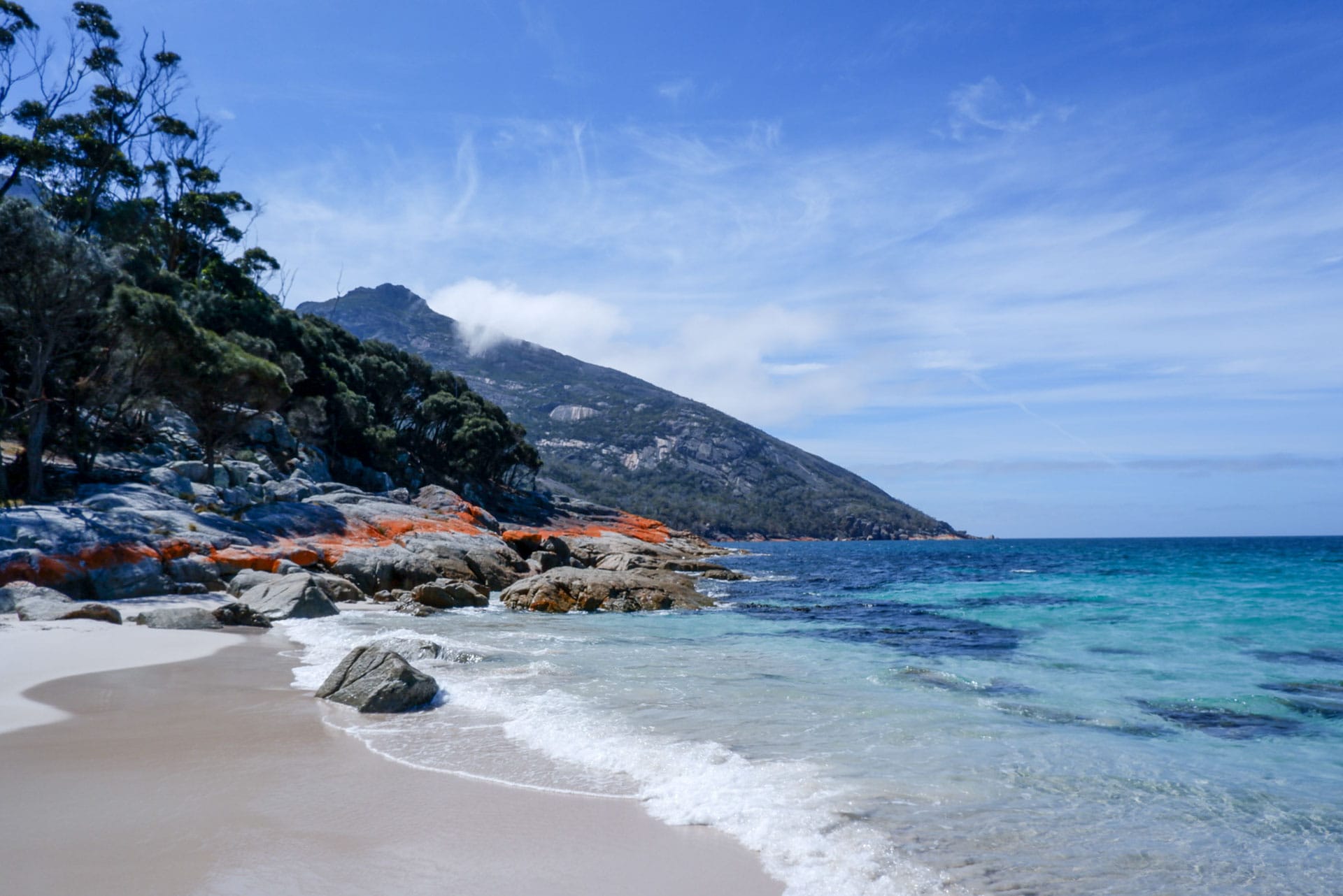 Wineglass Bay Walk – A Glorious Panoramic Trail Through Freycinet National Park, tasmania, freycinet, alltrails, itineraries, day hike, the shores of wineglass bay in tasmania with orange rocks