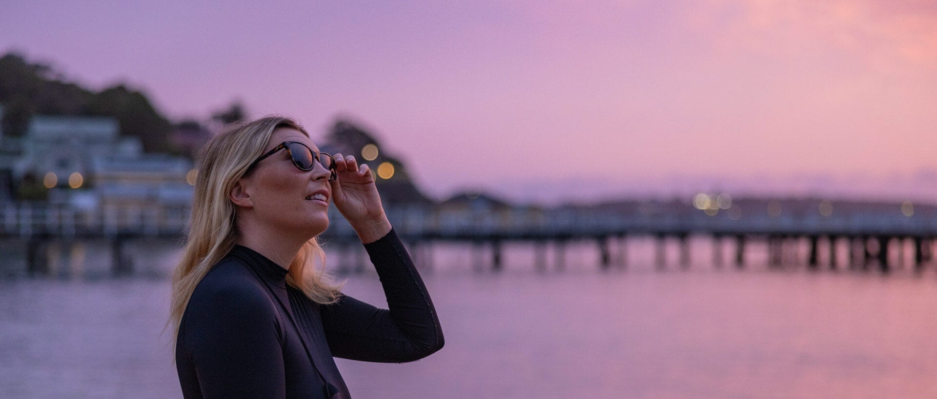 Meet Grumpy Turtle Films – The Company Telling Underwater Stories in The Name Of Conservation, conservation, photography, marine life, lady in wetsuit looking upwards with pink sunset in the background, sponsored, costa del mar, costa