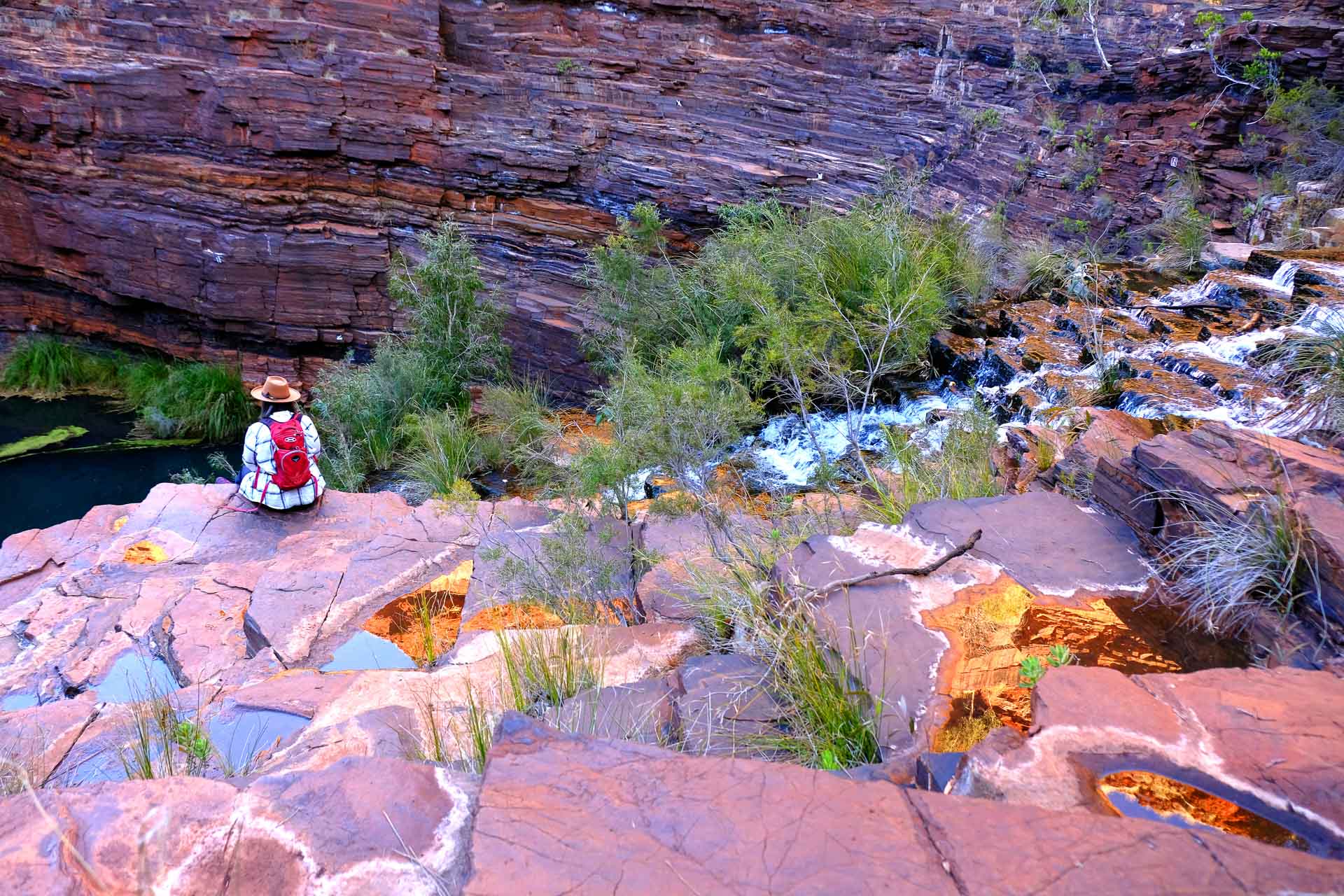 WA Has Announced the Top 150 Trails in the State, western australia, wa hikes, person sitting amongst red rock in dales gorge in western australia