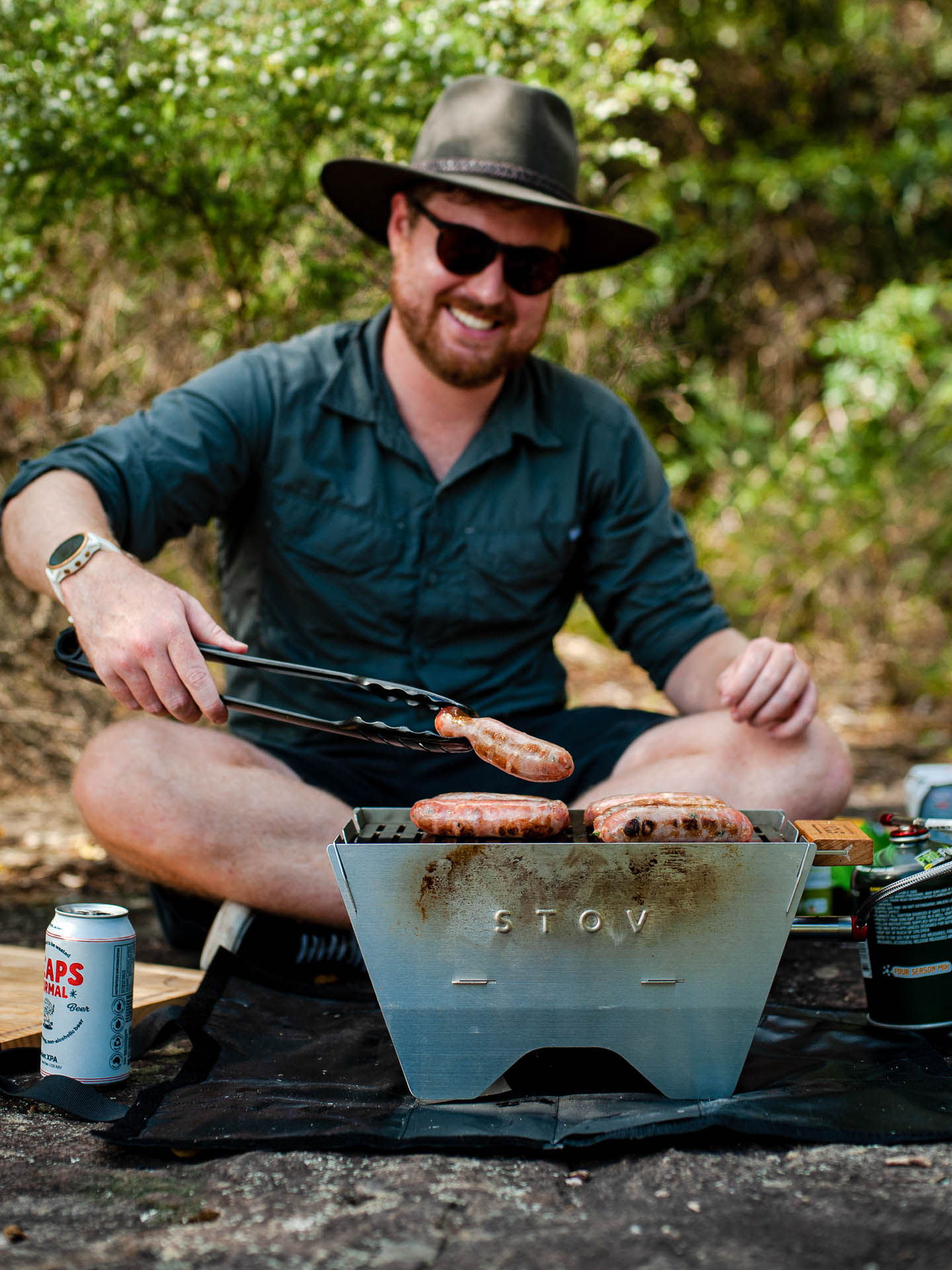 STOV Flatback Portable Gas BBQ – Gear Review & Test, tim ashelford, barbeque, stov bbq, man cooking sausages on an outdoorstov bbq