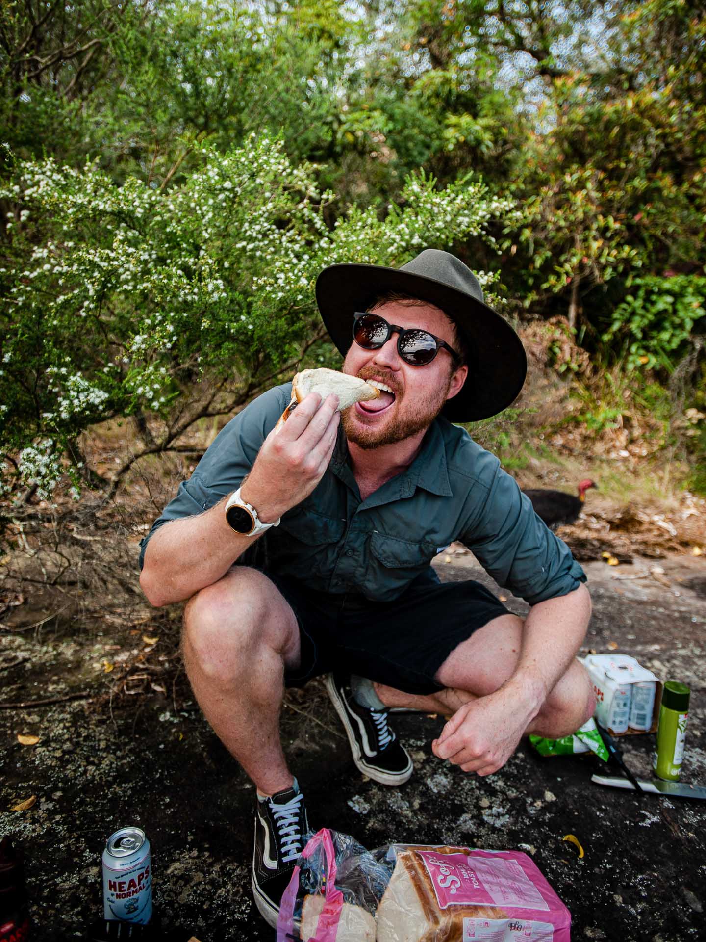 STOV Flatback Portable Gas BBQ – Gear Review & Test, tim ashelford, bbq, camping bbq, gear, stov bbq, man enjoying a sausage in bread after using the stov bbq outside