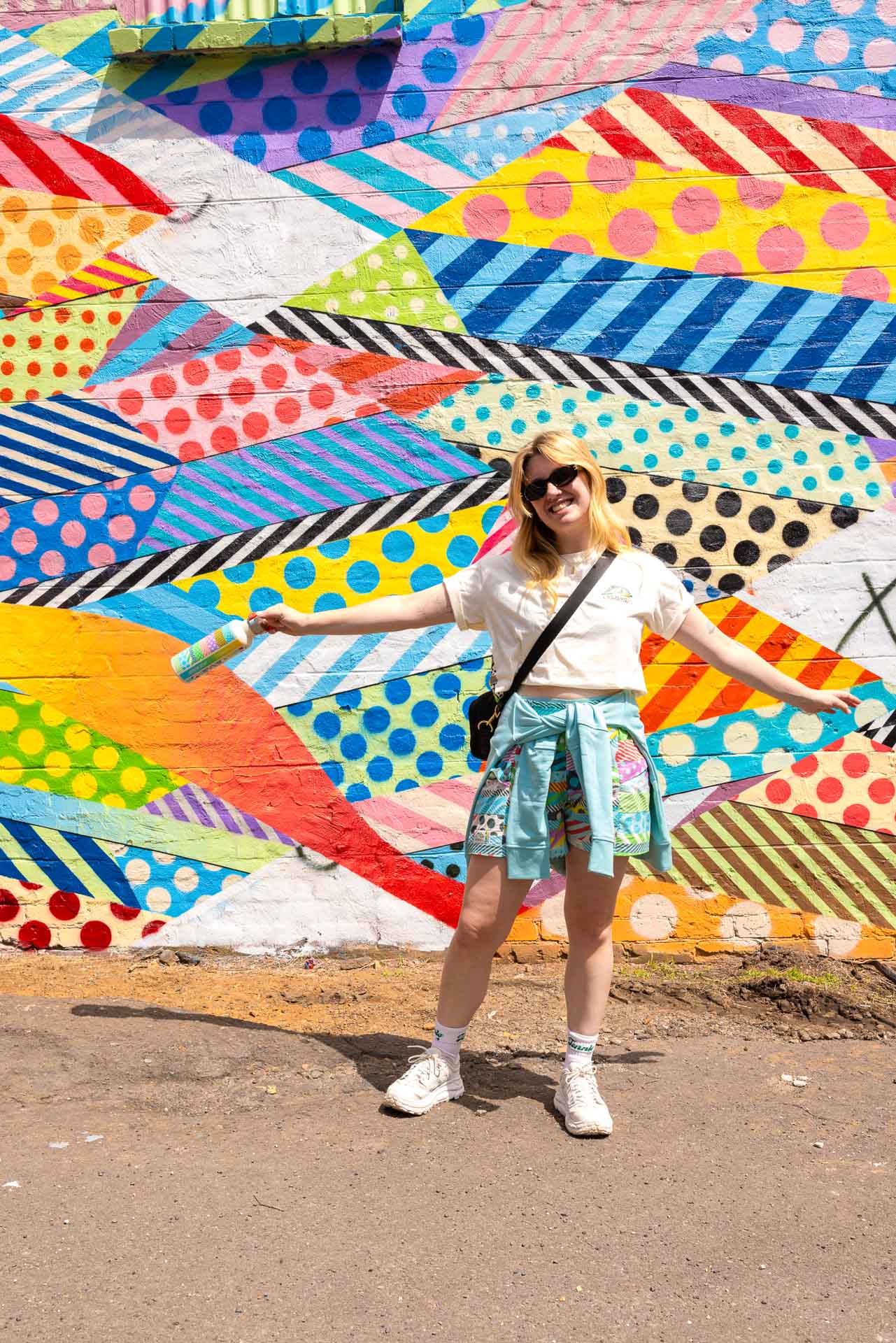 Kathmandu’s Zany New Collab With Jason Woodside Brings Bulk Colour to Your Outdoor Outfit, sponsored, outdoor gear, outdoor kit, outdoor fashion, lady posing in front of colourful mural in the blue mountains depicting the patternway used in the kathmandu x jason woodside collab