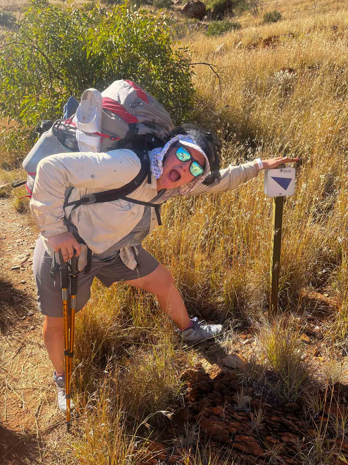 I Hiked the Larapinta Trail Solo With a 28kg Pack & Wouldn't Change a Thing, bree townsend, larapinta trail, northern territory hike, solo hiking, shiker leaning on post on the larapinta trail