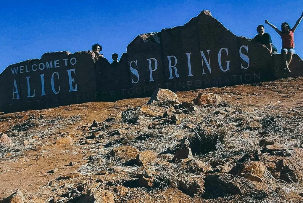 What a 3 Month Road Trip Taught Me That School Never Could, caitlin robson, road trip, family road trip, australian road trip, family posing in front of alice springs sign