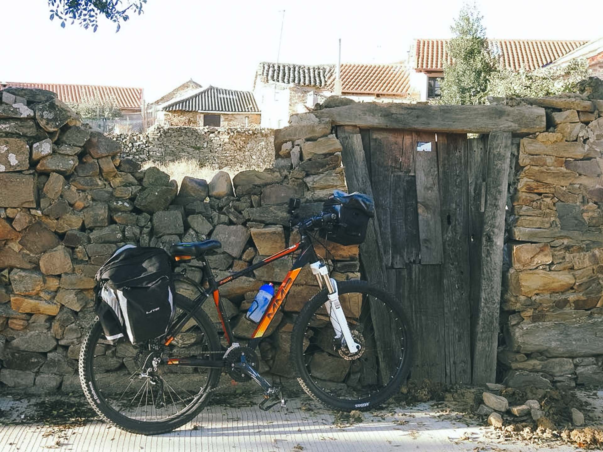 Paralyzed From the Neck Down to Cycling the Camino de Santiago: Meet the Unstoppable Cate Green, Photos by Cate Green, Q&A, MS, cycling, bike, bikepacking, camino de santiago, pilgrimage, bicycle resting on stone wall in spain