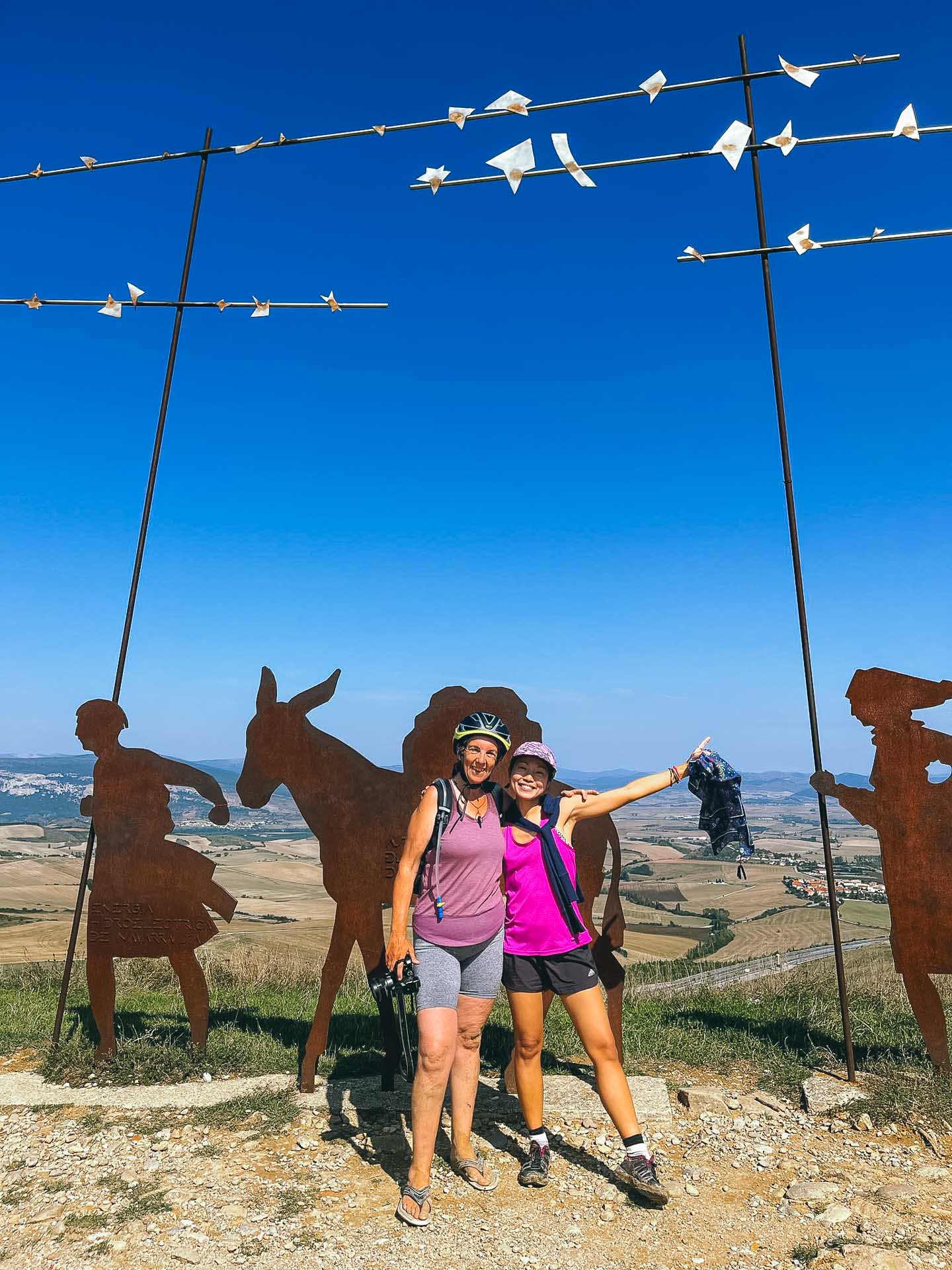 Paralyzed From the Neck Down to Cycling the Camino de Santiago: Meet the Unstoppable Cate Green, Photos by Cate Green, Q&A, MS, cycling, bike, bikepacking, camino de santiago, pilgrimage, posing in front of wrought iron figures on the camino