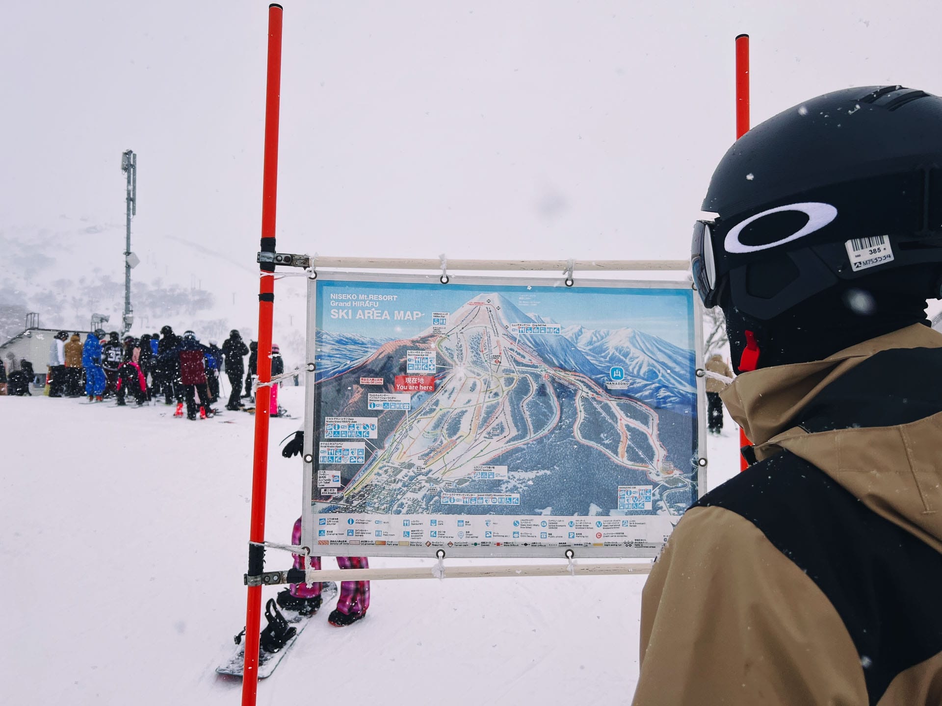 Skiing in Japan: Why Niseko Is Best For Beginners, Photo by Ally Burnie, skiing, japan, niseko, skiing guide, skiier standing in front of the outdoor niseko ski map