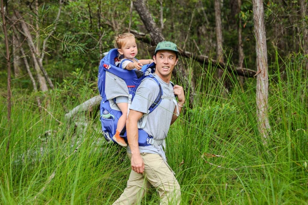 How I’m Spending More Time Outdoors With My Baby, Photo by Casey Fung, gear, comparison, child carrier, sponsored, wild earth, osprey, father and child in osprey poco plus child carrier hiking through long grass