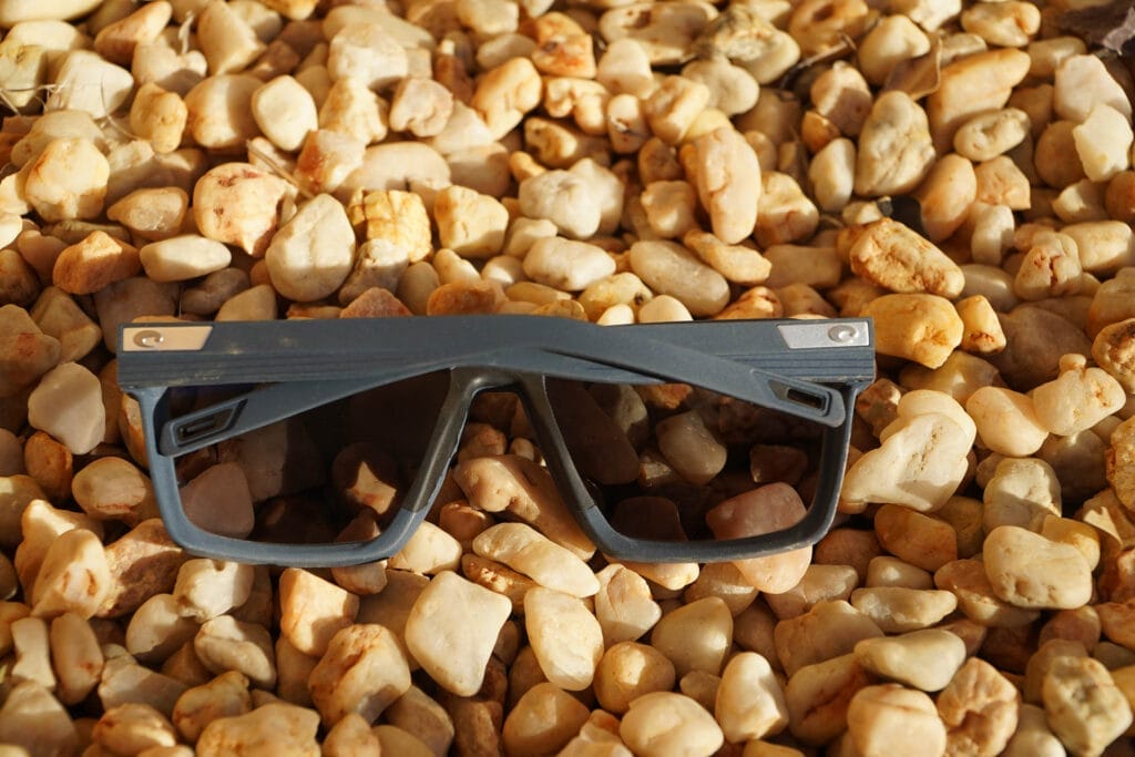 Costa Del Mar's Antille Polarised Sunglasses – Reviewed & Tested, costa del mar, Photo by Josh Fletcher, gear review, pair of antille sunglasses sitting on pebbles showing arms folded at the back