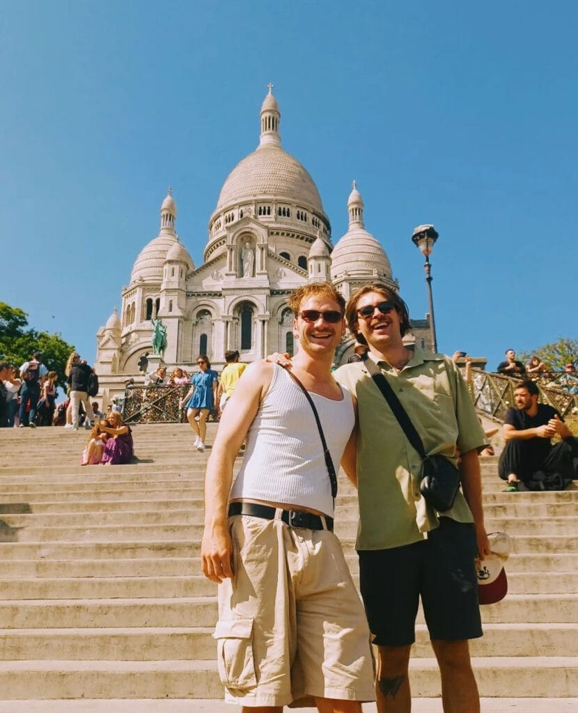 How I Use Dating Apps to Create Communities When Travelling, Photo by Andy Leake, LGBTQIA+, two friends posing in front of montmarte in paris, france